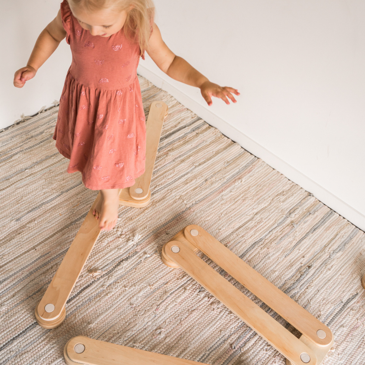 Toddler playing on wooden balance beams